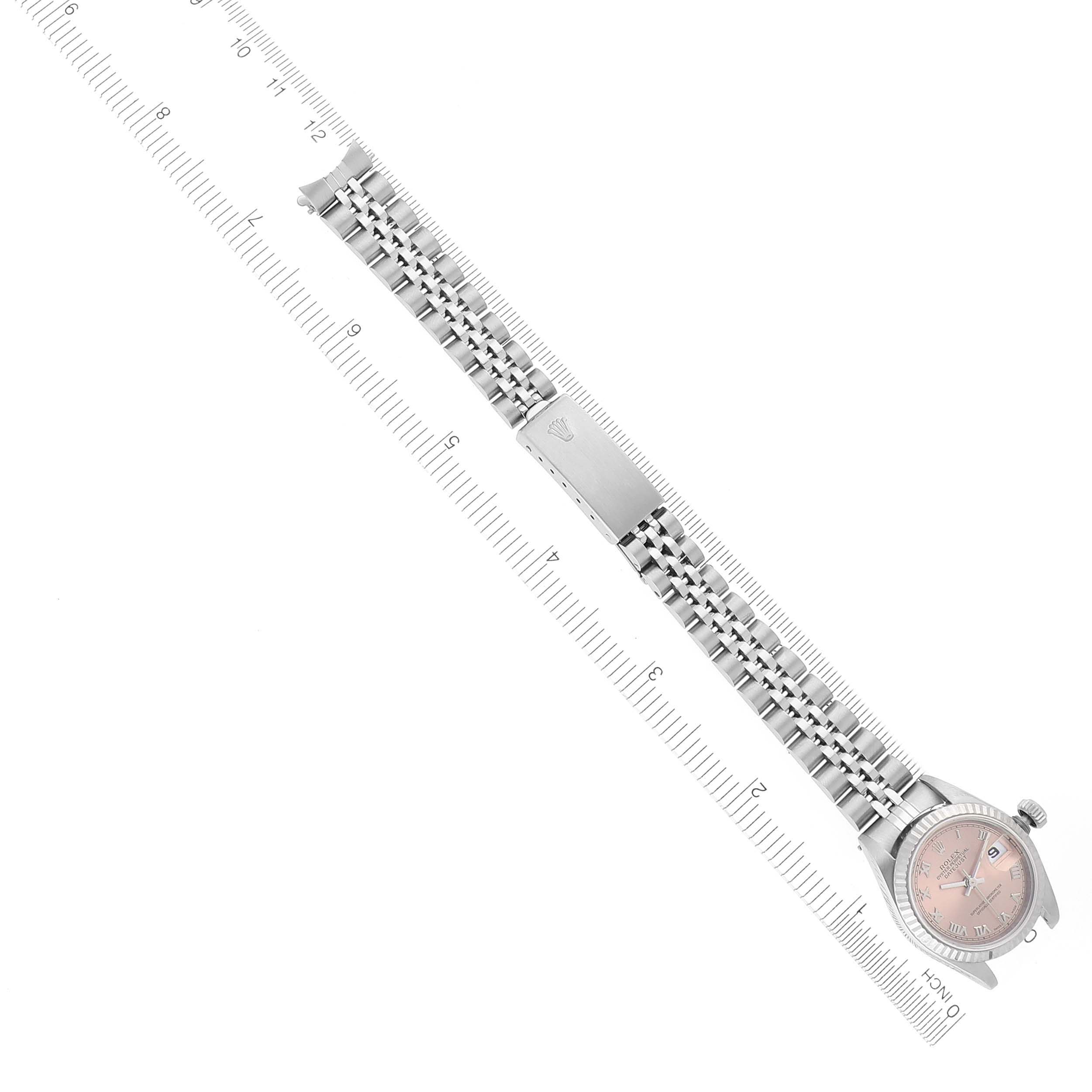 The Rolex Datejust 69174 Women's Stainless Steel Pink Dial 69174 Women's Stainless Steel Pink Dial watch is shown from a top view, displaying its full bracelet and face, aligned along a ruler.