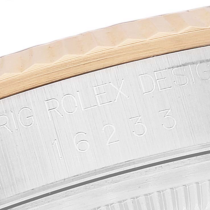 The close-up image shows the serial and model numbers engraved on the side of a Rolex Datejust 16233 Men's Steel and Gold (two tone) Blue Dial 16233 Men's Steel and Gold (two tone) Blue Dial watch bezel.