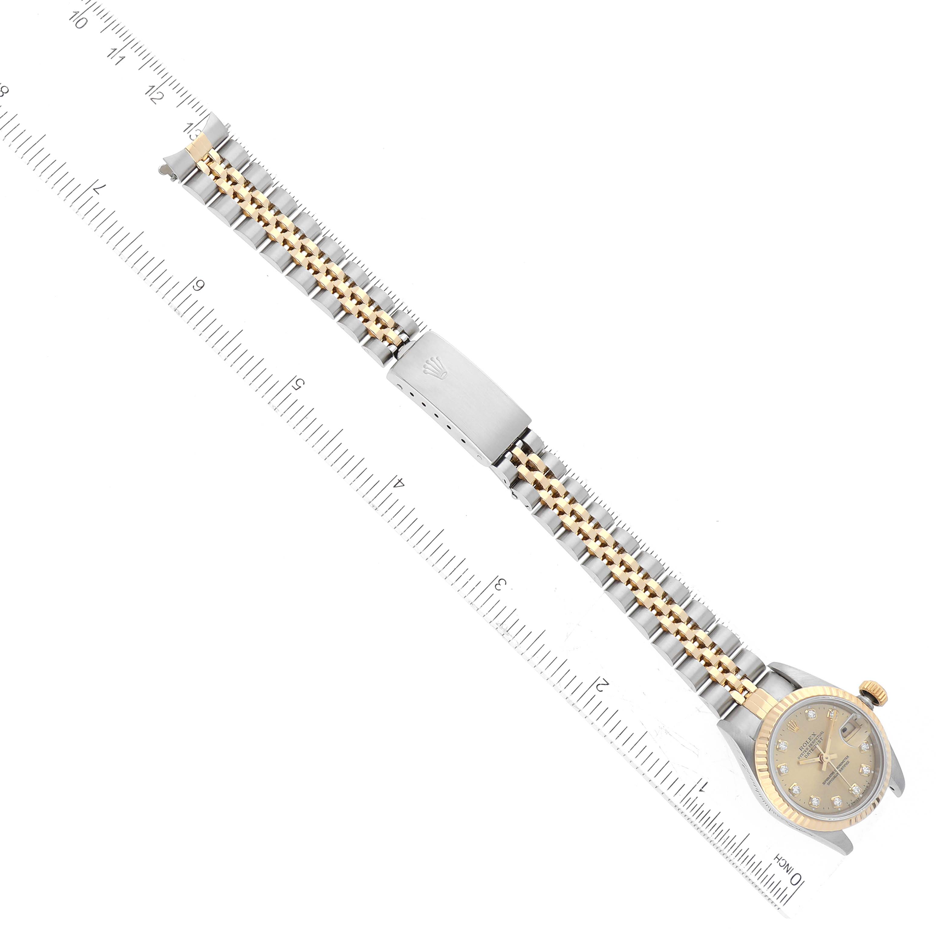 The image shows a top view of a Rolex Datejust 69173 Women's Steel and Gold (two tone) Champagne Dial 69173 Women's Steel and Gold (two tone) Champagne Dial watch with its bracelet, alongside a ruler for scale.