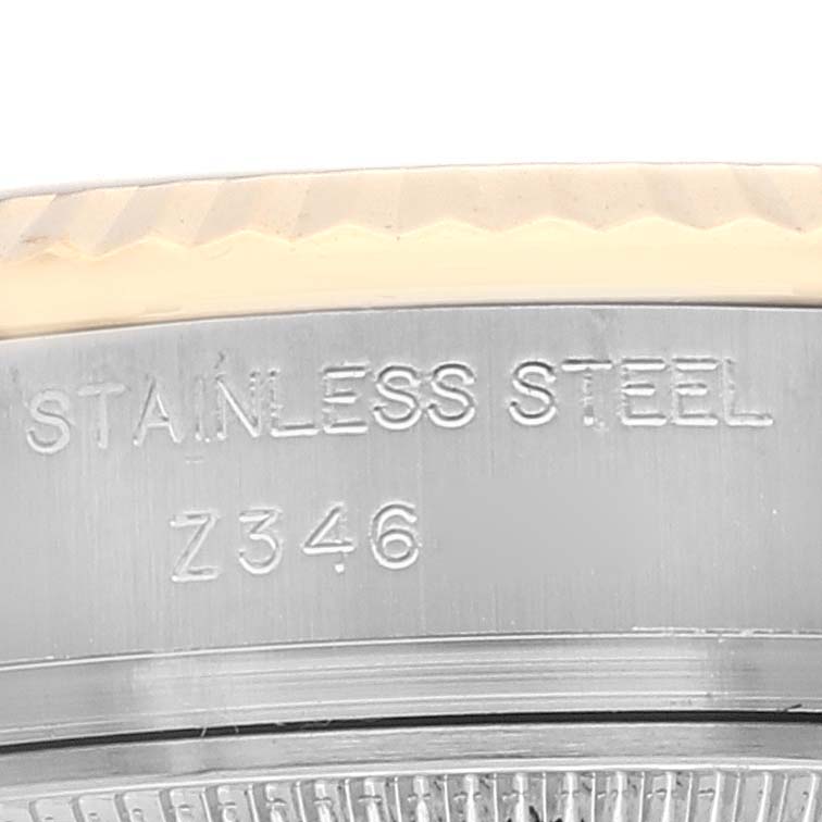 This image shows a close-up of the bezel and the side of the case of a Rolex Datejust 179173 Women's Steel and Gold (two tone) Mother of Pearl Dial 179173 Women's Steel and Gold (two tone) Mother of Pearl Dial model, featuring engraving details.