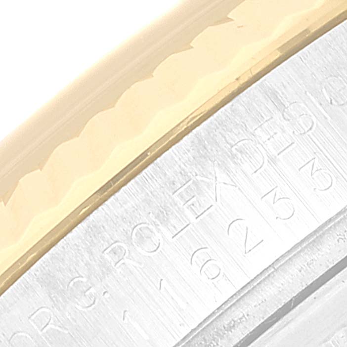 This is a macro shot of the engraved inner bezel and fluted bezel of a Rolex Datejust 116233 Men's Steel and Gold (two tone) Mother of Pearl Dial 116233 Men's Steel and Gold (two tone) Mother of Pearl Dial watch.