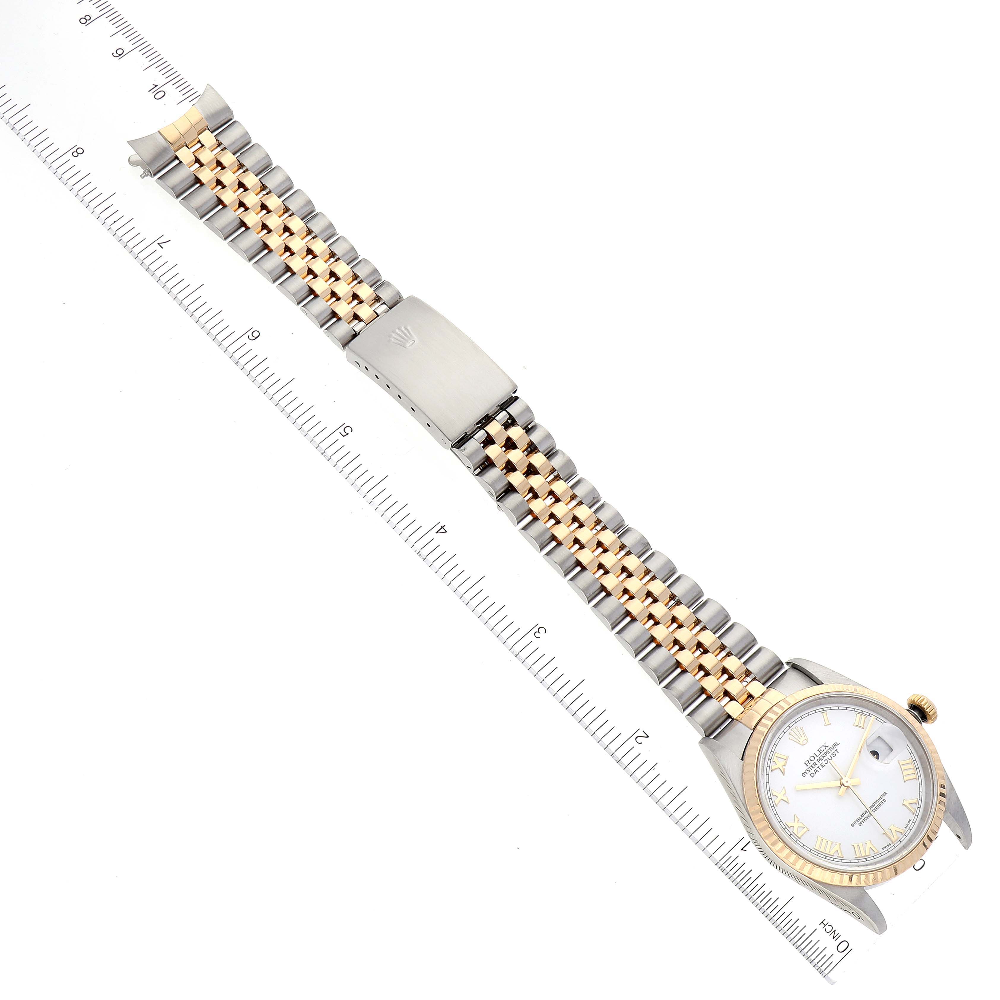 The image shows a Rolex Datejust 16233 Men's Steel and Gold (two tone) White Dial 16233 Men's Steel and Gold (two tone) White Dial model watch, laid flat with the bracelet extended, alongside a ruler for scale.
