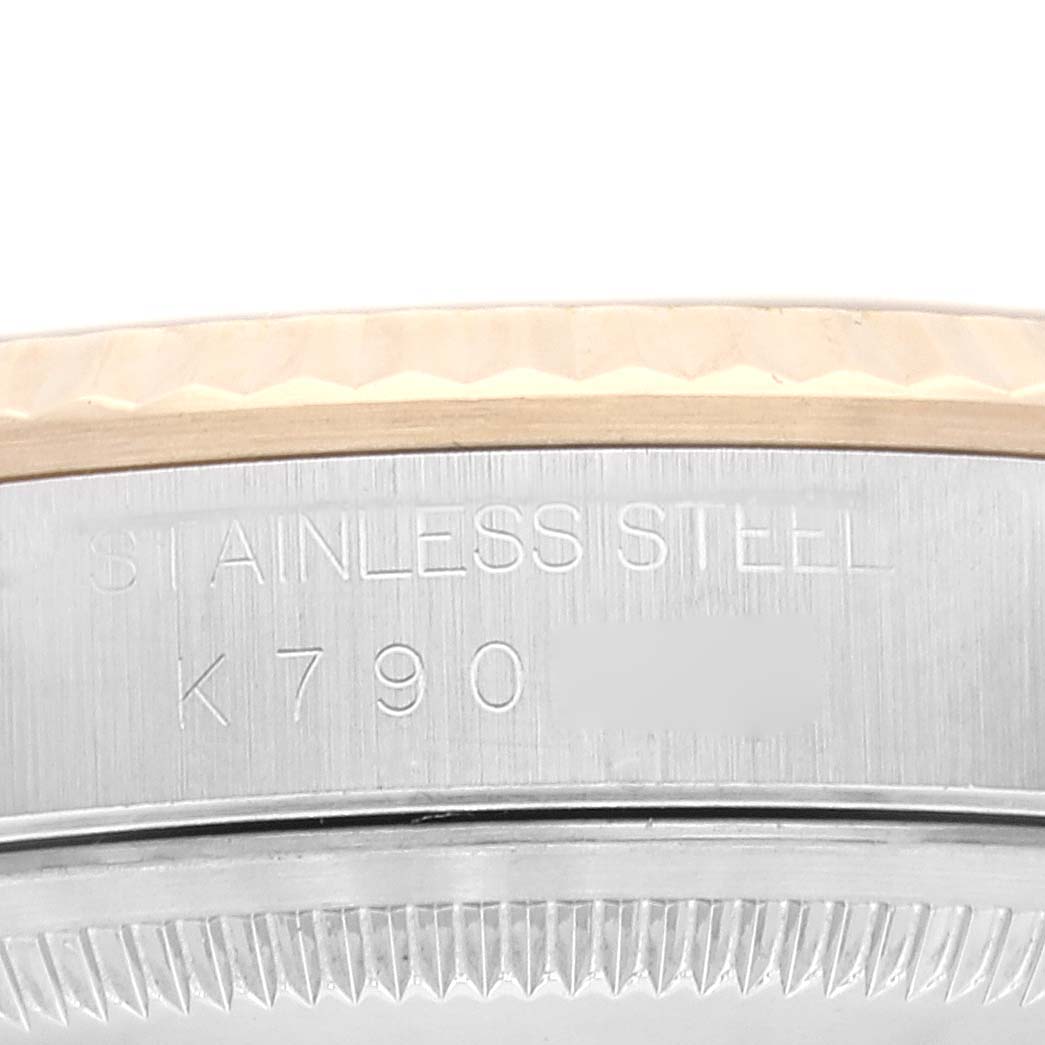 This image shows a close-up of the side of a Rolex Datejust 16233 Men's Steel and Gold (two tone) White Dial 16233 Men's Steel and Gold (two tone) White Dial watch, focusing on the serial engraving and part of the bezel.