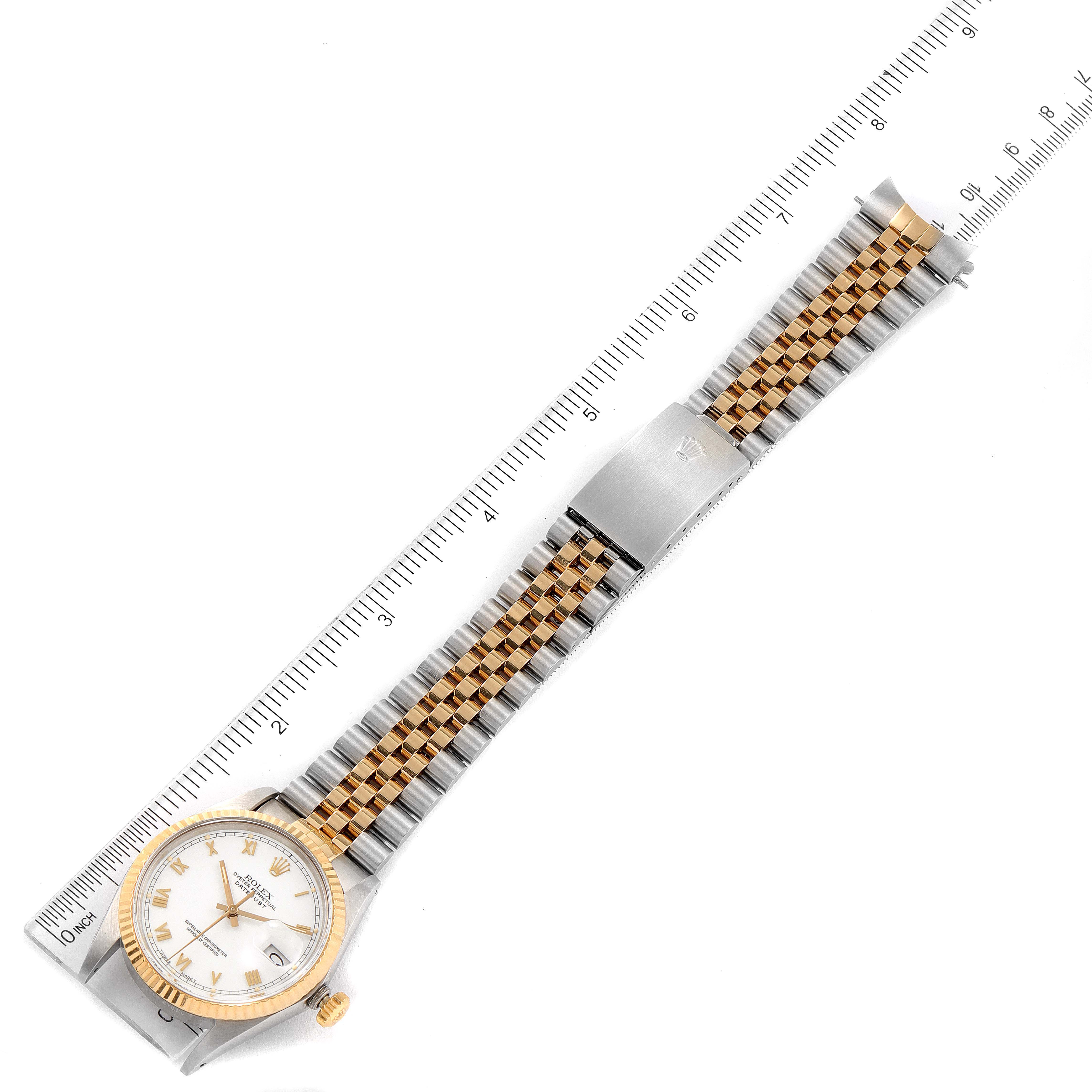 This image shows the Rolex Vintage Collection 16013 Men's Steel and Gold (two tone) White Dial 16013 Men's Steel and Gold (two tone) White Dial model watch laid flat with its gold and silver bracelet fully extended beside a ruler for scale.