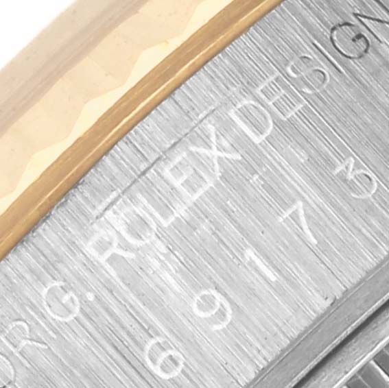 The image shows a close-up of the Rolex Datejust 69173 Women's Steel and Gold (two tone) White Dial 69173 Women's Steel and Gold (two tone) White Dial's case edge, highlighting the engraved details.