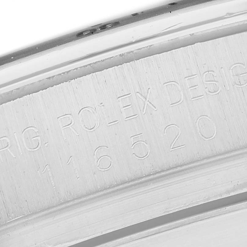 The image shows a close-up of the inner case engraving on a Rolex Daytona 116520 Men's Stainless Steel Black Dial, displaying model and brand details.