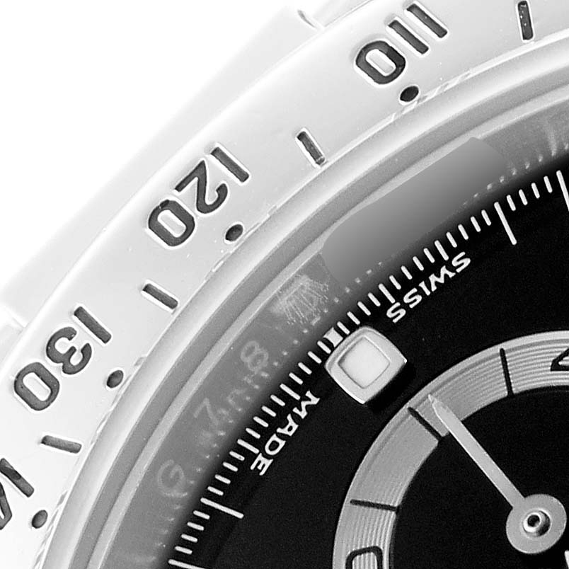 The image shows a close-up of the bezel and part of the dial of a Rolex Daytona 116520 Men's Stainless Steel Black Dial watch, highlighting numerals and indices.
