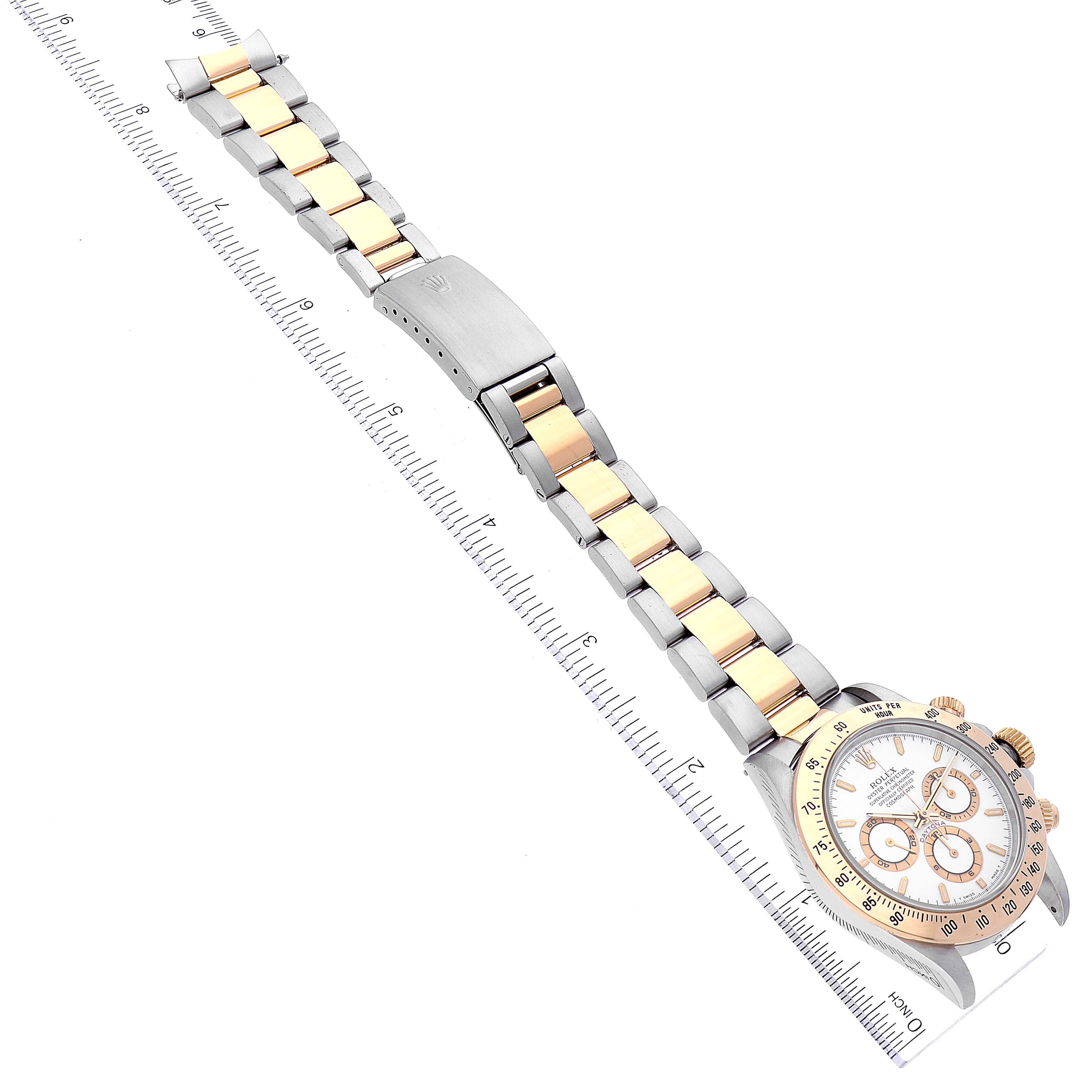 This image shows a top-down view of a Rolex Daytona 16523 Men
s Steel and Gold (two tone) White Dial 16523 Men
s Steel and Gold (two tone) White Dial watch, focusing on the band and face alongside a ruler for scale.