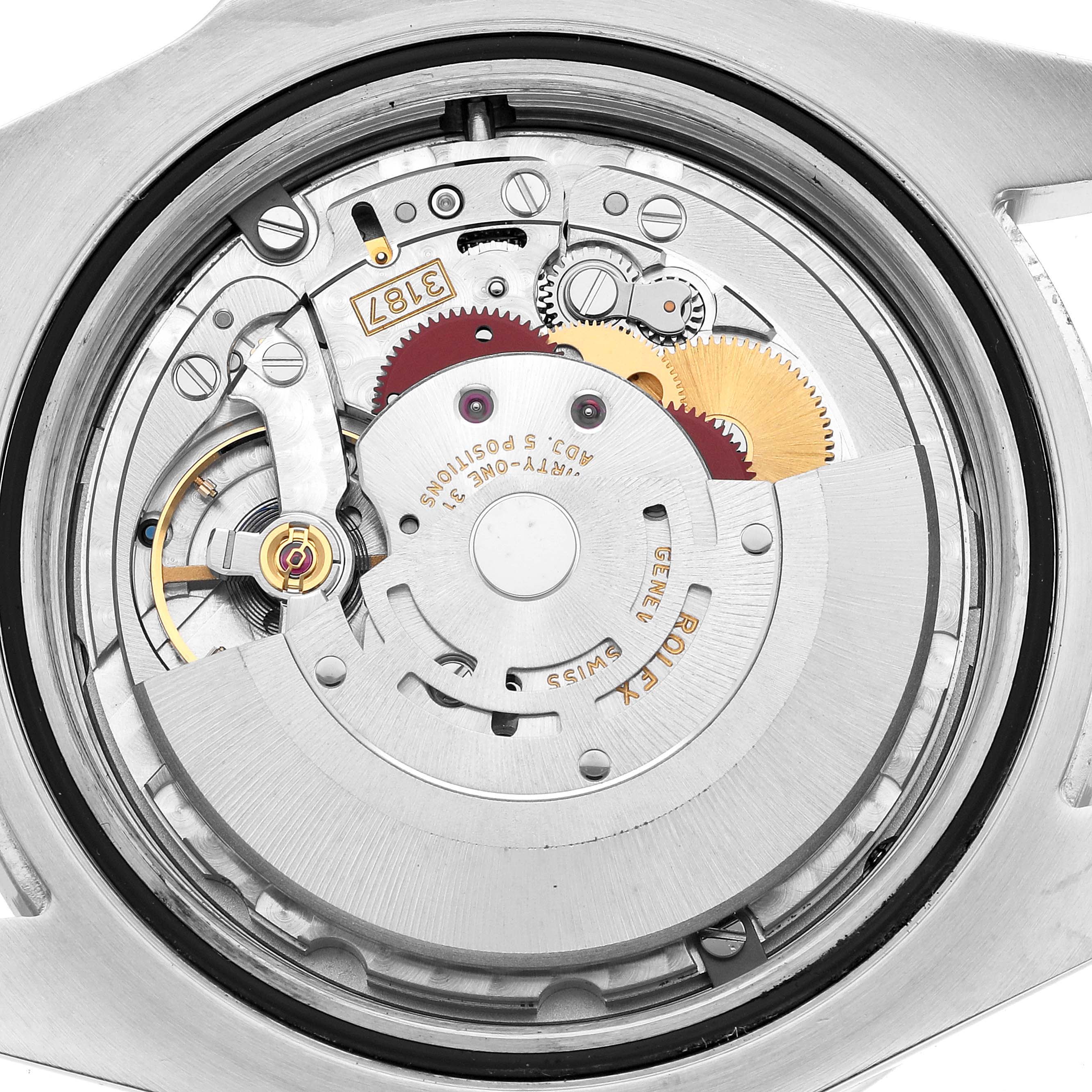 The image shows the movement of a Rolex Explorer 216570 Men's Stainless Steel White Dial watch, viewed from the back, highlighting gears and mechanical components.