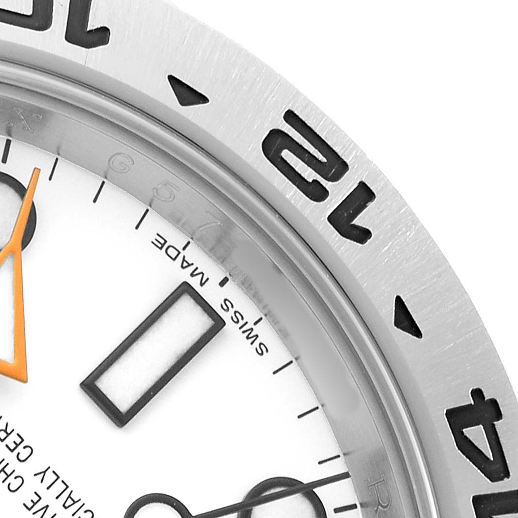 The image shows a close-up of the bezel, partial dial, and hands of the Rolex Explorer 216570 Men's Stainless Steel White Dial watch.