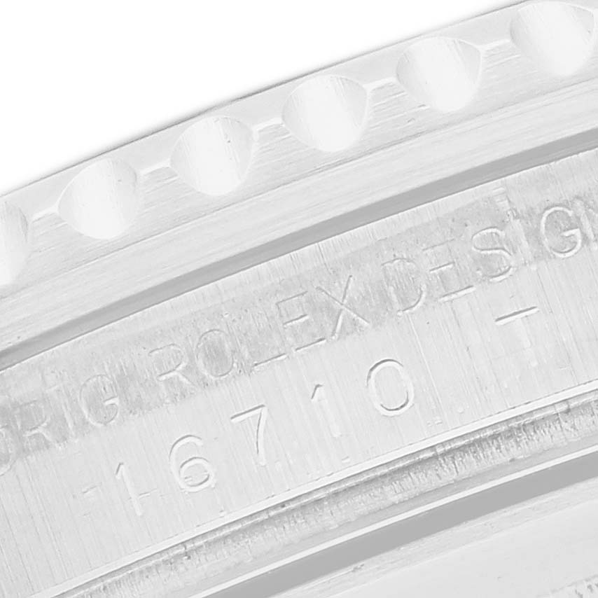 The image shows a close-up of the engraved side and bezel teeth of a Rolex GMT-Master 16710 Men's Stainless Steel Black Dial watch, model 16710.