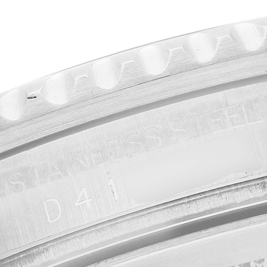 The image shows a close-up of the serrated edge and engraving on the bezel side of a Rolex GMT-Master 16710 Men's Stainless Steel Black Dial watch.