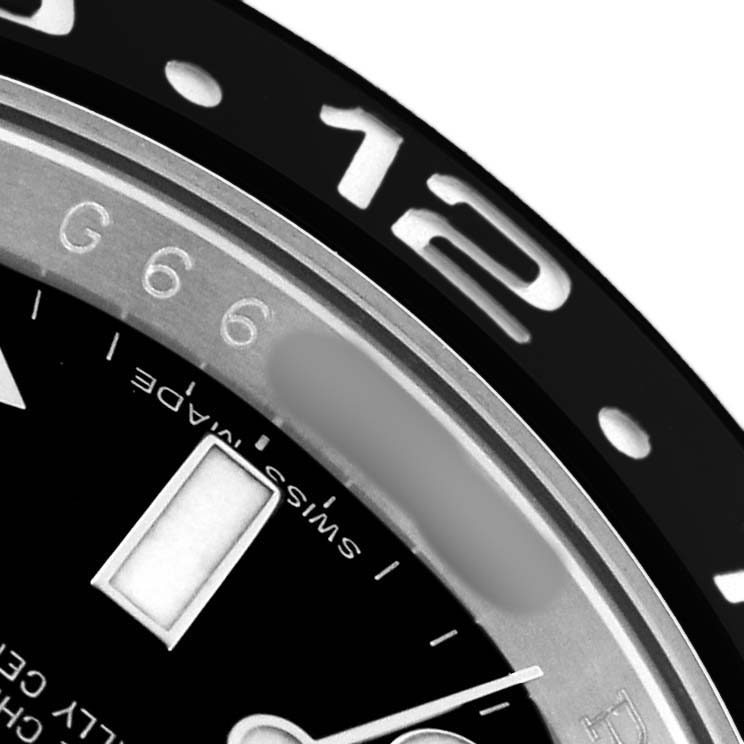 The image shows a close-up of the bezel and dial of a Rolex GMT-Master 116710LN Men's Stainless Steel Black Dial, highlighting the 12-hour mark and part of the face.