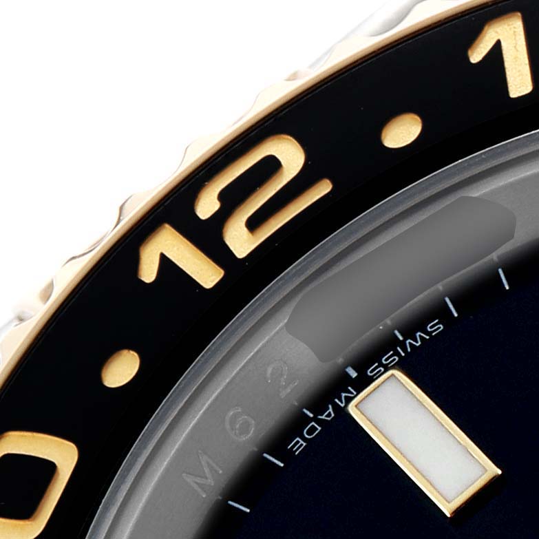 This image shows a close-up of the bezel and dial edge of a Rolex GMT-Master 116713 Men's Steel and Gold (two tone) Black Dial, highlighting the "12" marker and "Swiss Made" text.