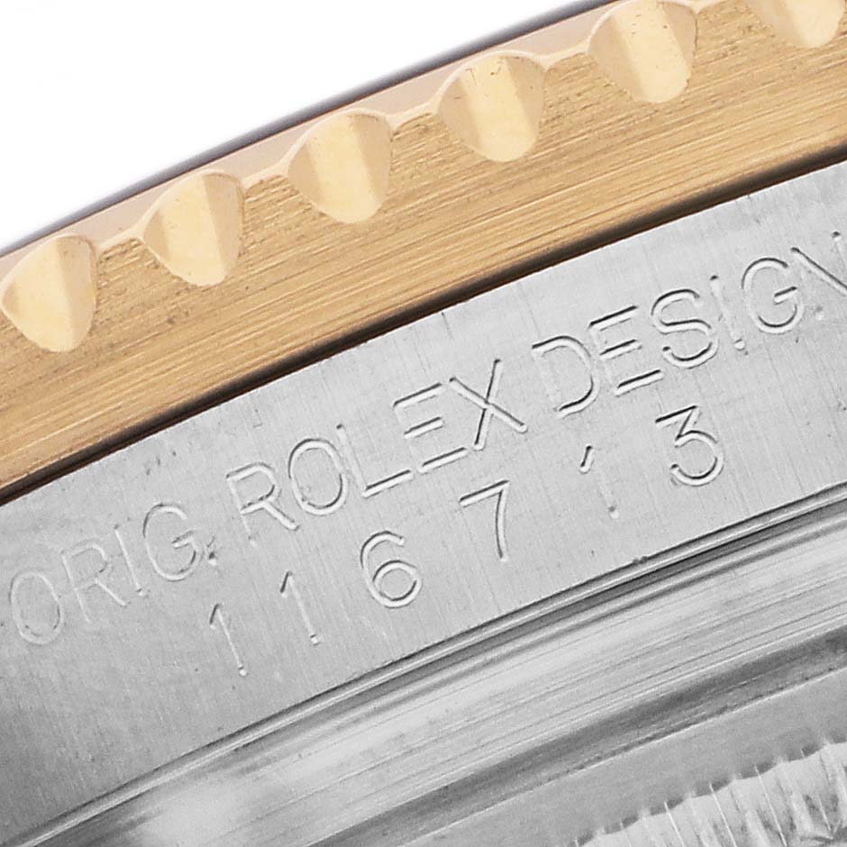 The image shows a close-up of the bezel and engraving on the Rolex GMT-Master 116713 Men's Steel and Gold (two tone) Black Dial, highlighting the model number.