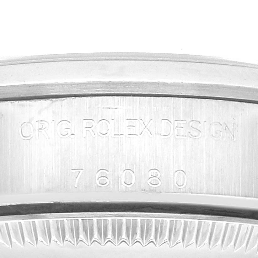 This image shows a close-up of the side of a Rolex Oyster Perpetual 76080 Women's Stainless Steel Black Dial 76080 Women's Stainless Steel Black Dial watch, highlighting the "ORIG. ROLEX DESIGN" engravings and model number.