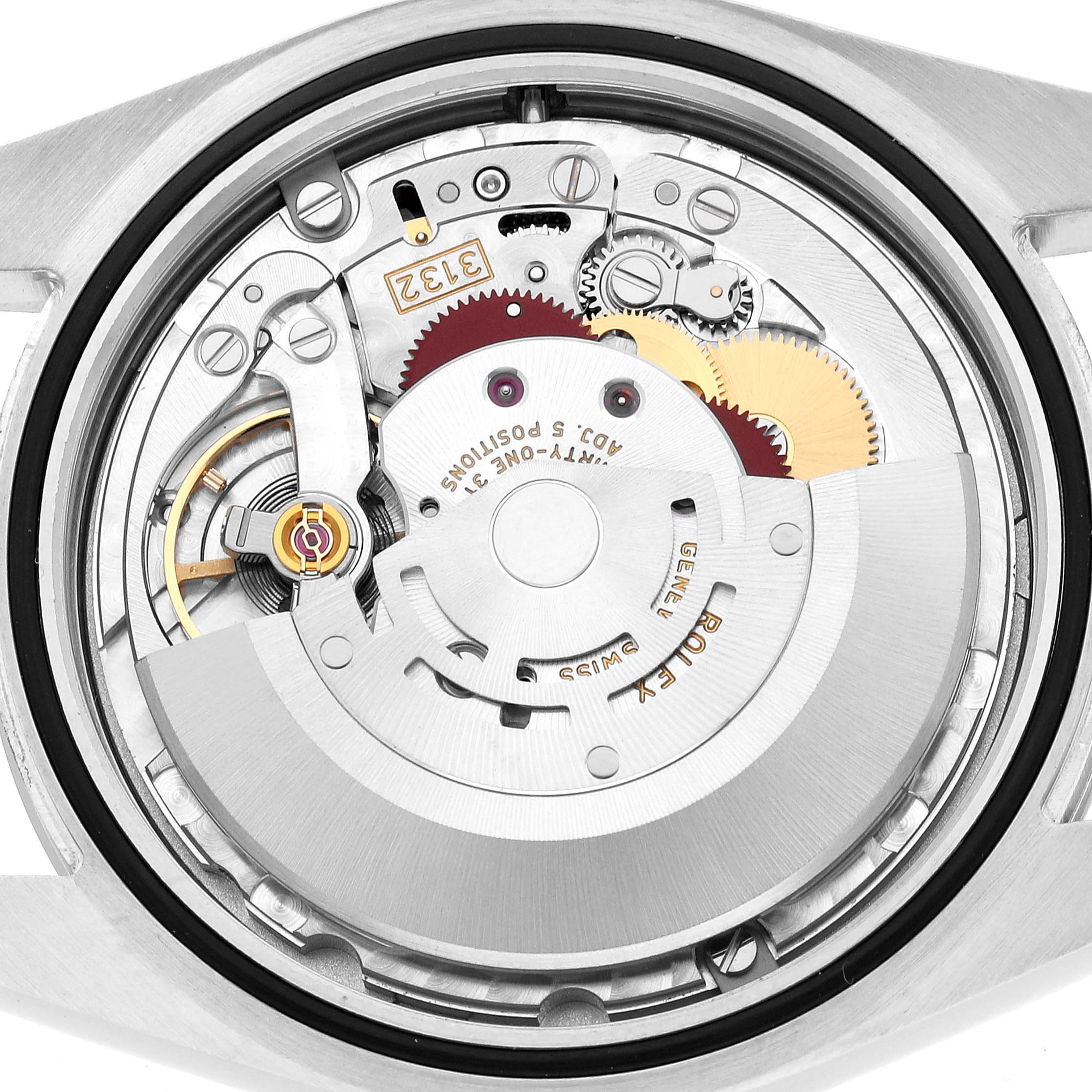 The image shows the movement of a Rolex Oyster Perpetual 114300 Men's Stainless Steel Grey Dial from a back angle, highlighting gears and rotor components.