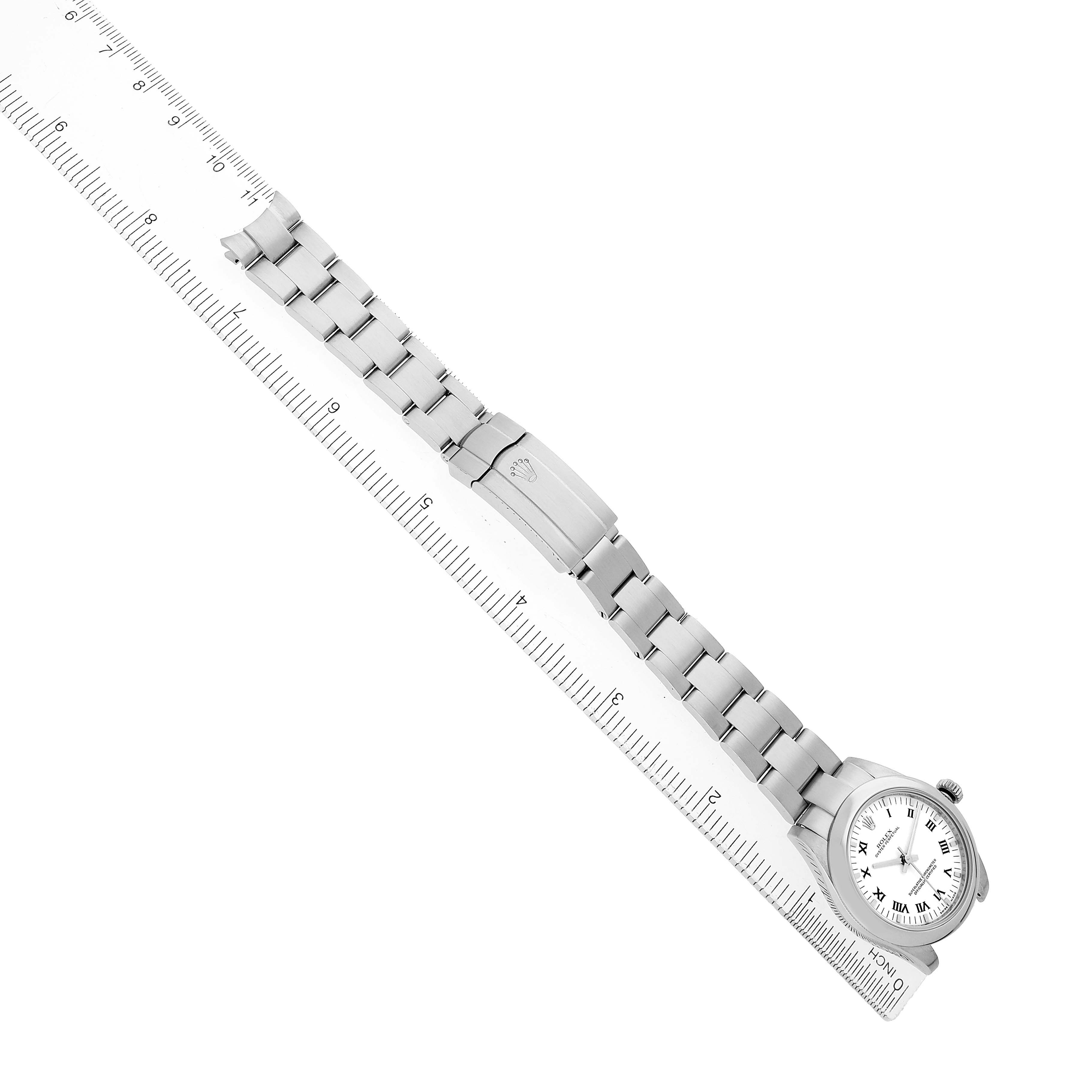 The Rolex Mid-Size 177200 Women's Stainless Steel White Dial watch is shown from a top-down angle, displaying the full bracelet and face alongside a ruler for scale.