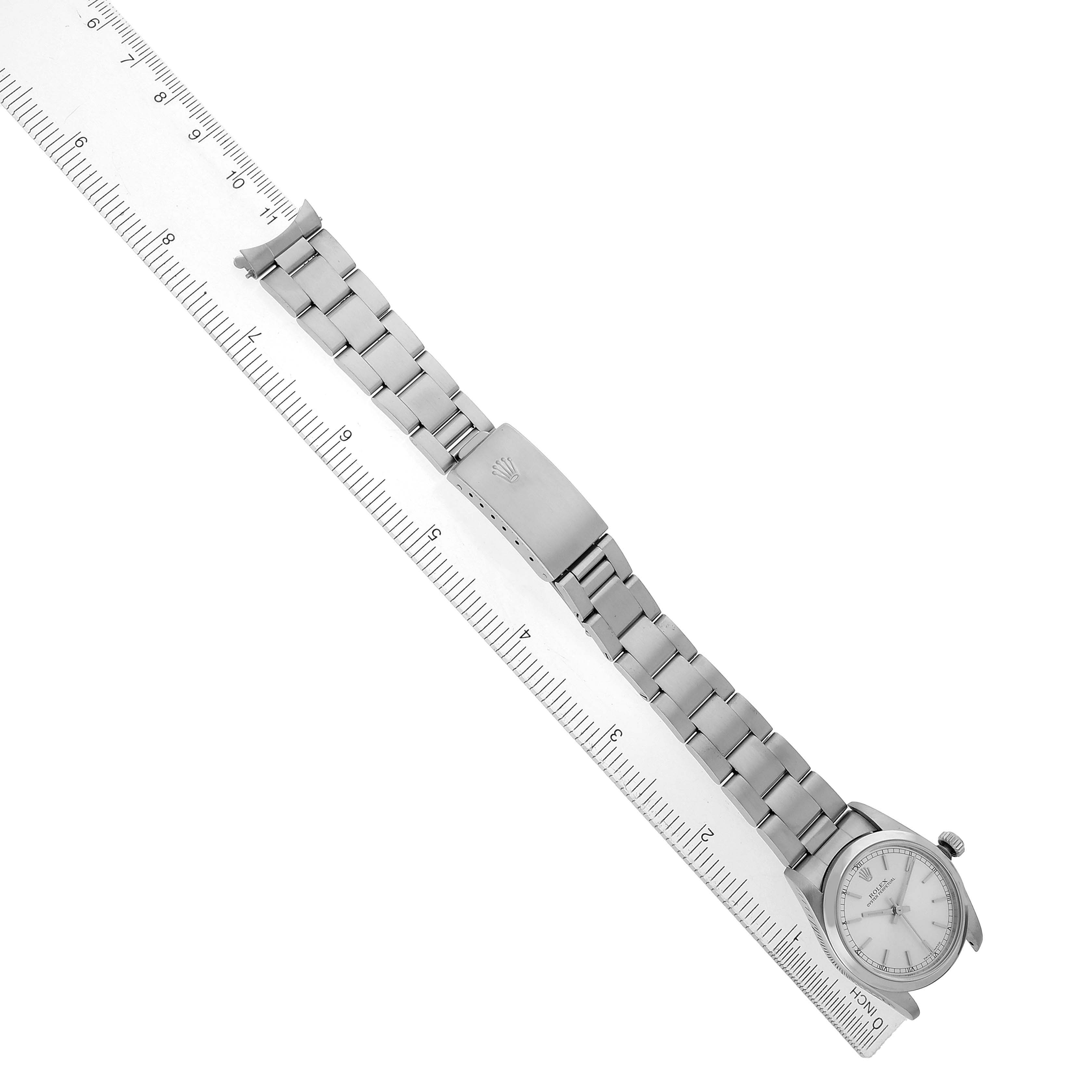 The Rolex Mid-Size 77080 Women's Stainless Steel Silver Dial watch is shown from a top-down angle, displaying the face, bezel, and full metal bracelet with clasp.