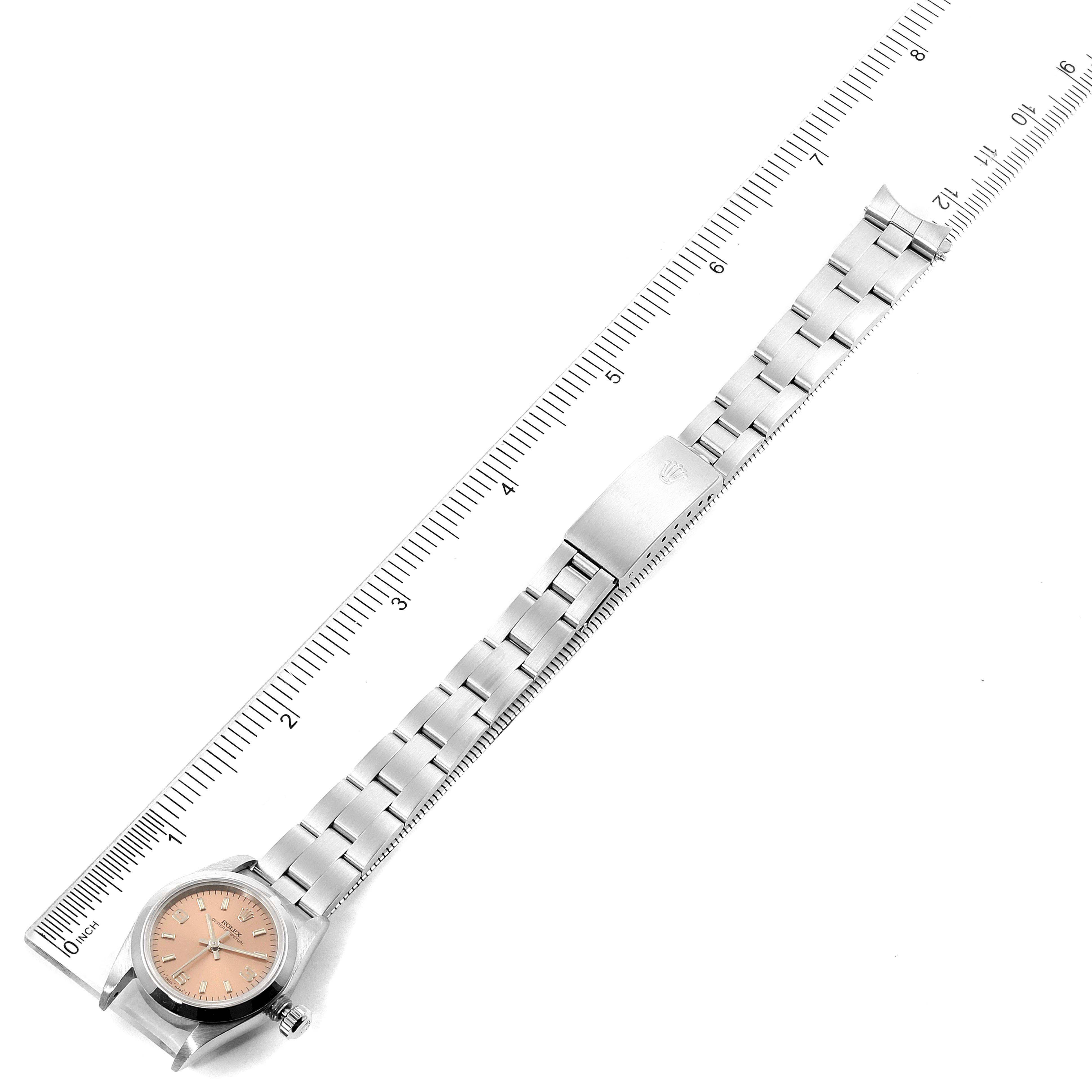 The image shows a top view of a Rolex Oyster Perpetual 67180 Women's Stainless Steel Pink Dial 67180 Women's Stainless Steel Pink Dial watch with its face, bracelet, and clasp parts.