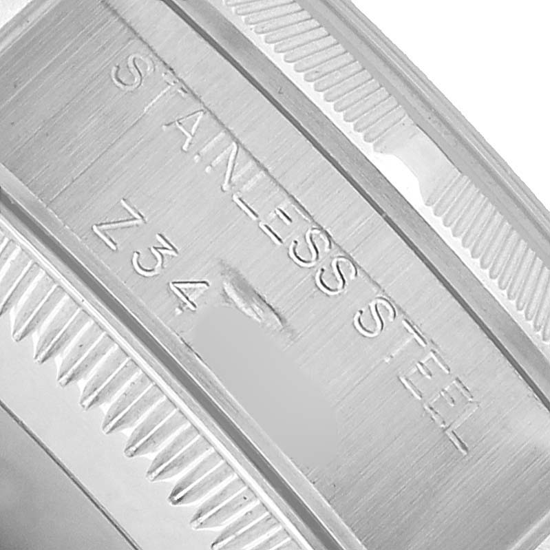 The image shows a close-up of the case edge of a Rolex Oyster Perpetual 76030 Women's Stainless Steel Black Dial, highlighting the stainless steel engraving.