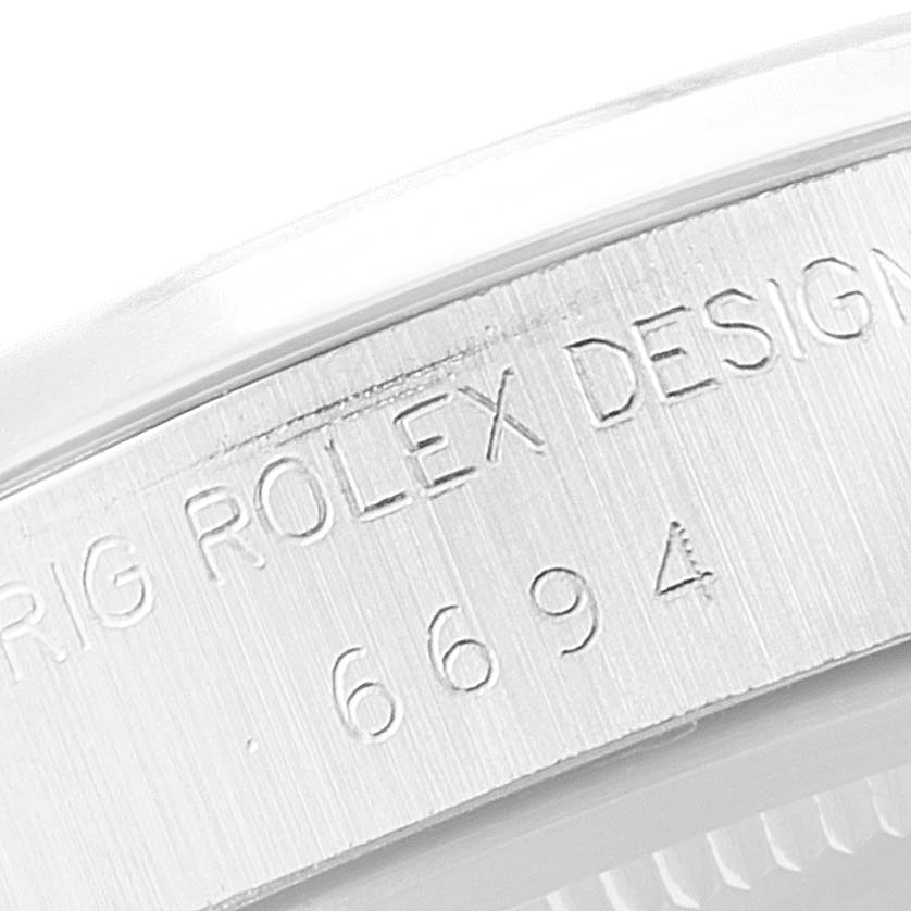 This image shows an engraved close-up of the side of a Rolex Vintage Collection 6694 Men's Stainless Steel Silver Dial 6694 Men's Stainless Steel Silver Dial model, displaying its design and reference number.