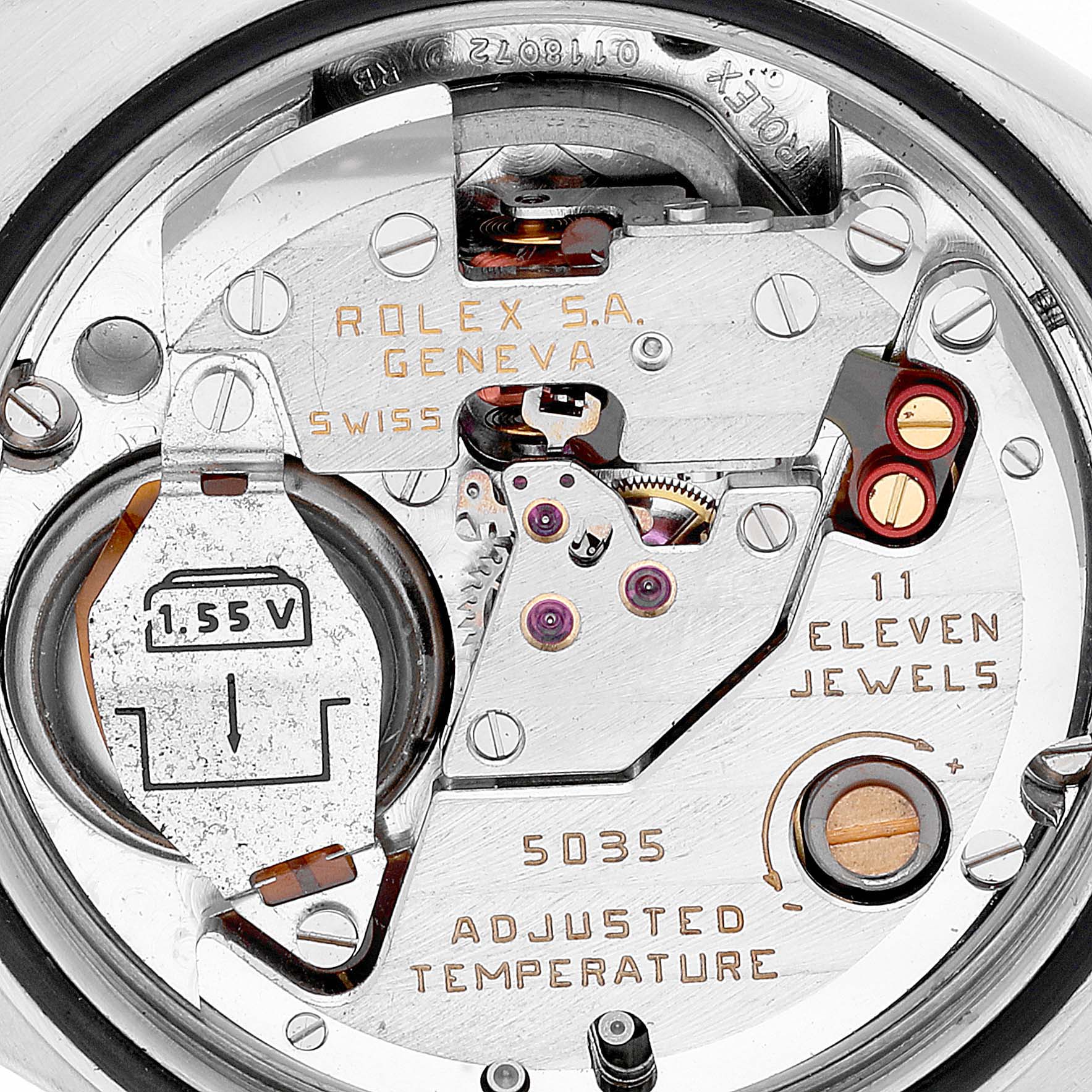 The image shows a close-up of the inner mechanism of the Rolex Oysterquartz 17013 Men's Steel and Gold (two tone) Champagne Dial 17013 Men's Steel and Gold (two tone) Champagne Dial watch, highlighting its battery, jewels, and inscriptions.