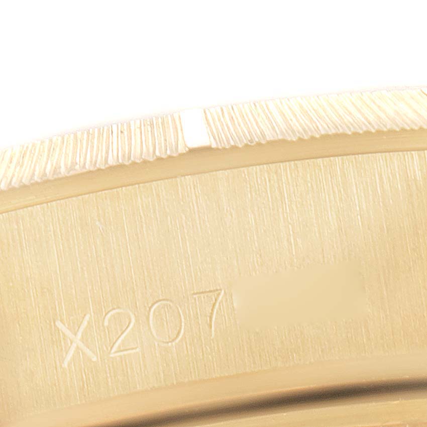 The image shows a close-up of the serial number area and a portion of the bezel of a Rolex President 69278 Women
s Yellow Gold White Dial 69278 Women
s Yellow Gold White Dial model watch.