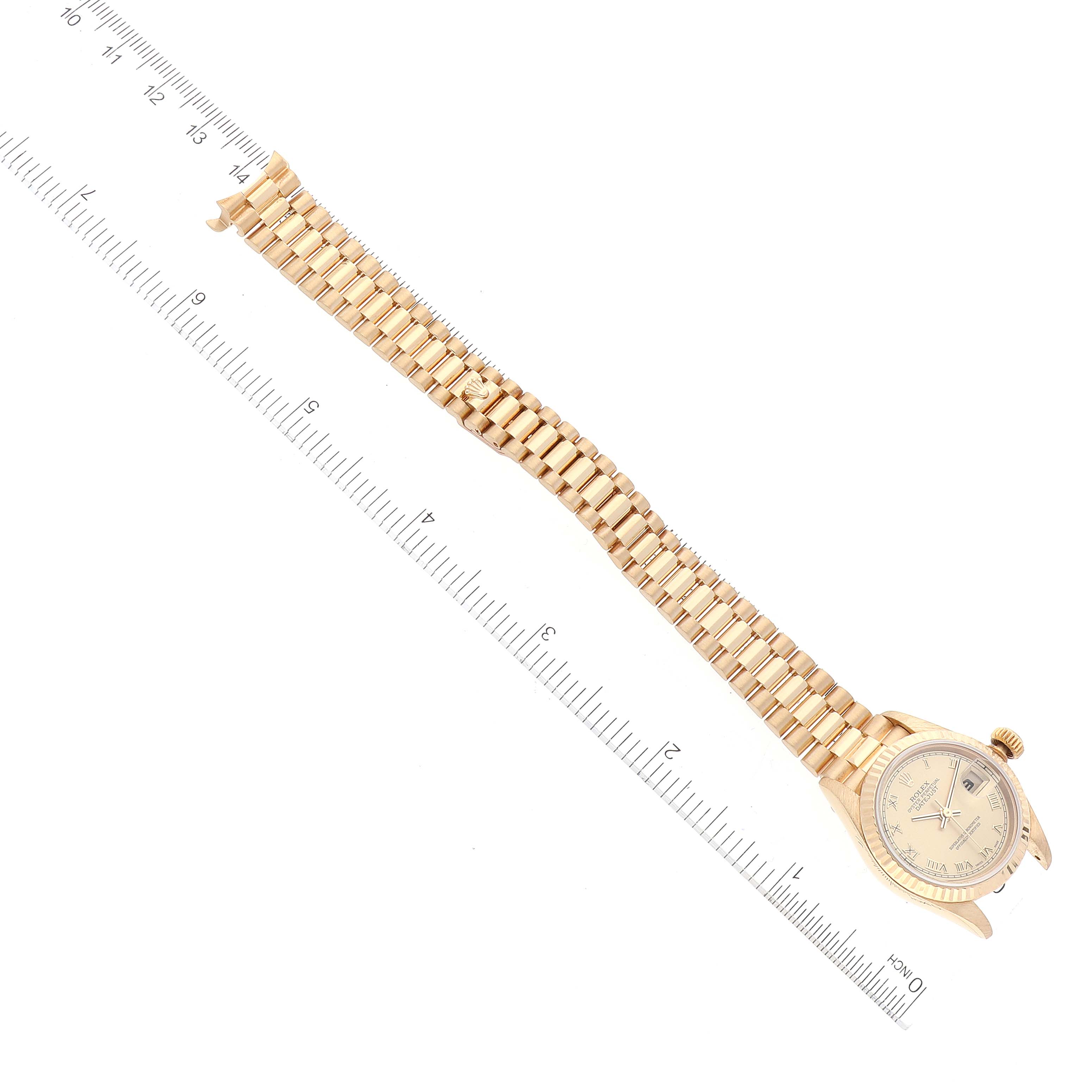 The Rolex President 79178 Women
s Yellow Gold Champagne Dial 79178 Women
s Yellow Gold Champagne Dial watch is shown laid flat with its face and band visible, placed alongside a ruler for scale.