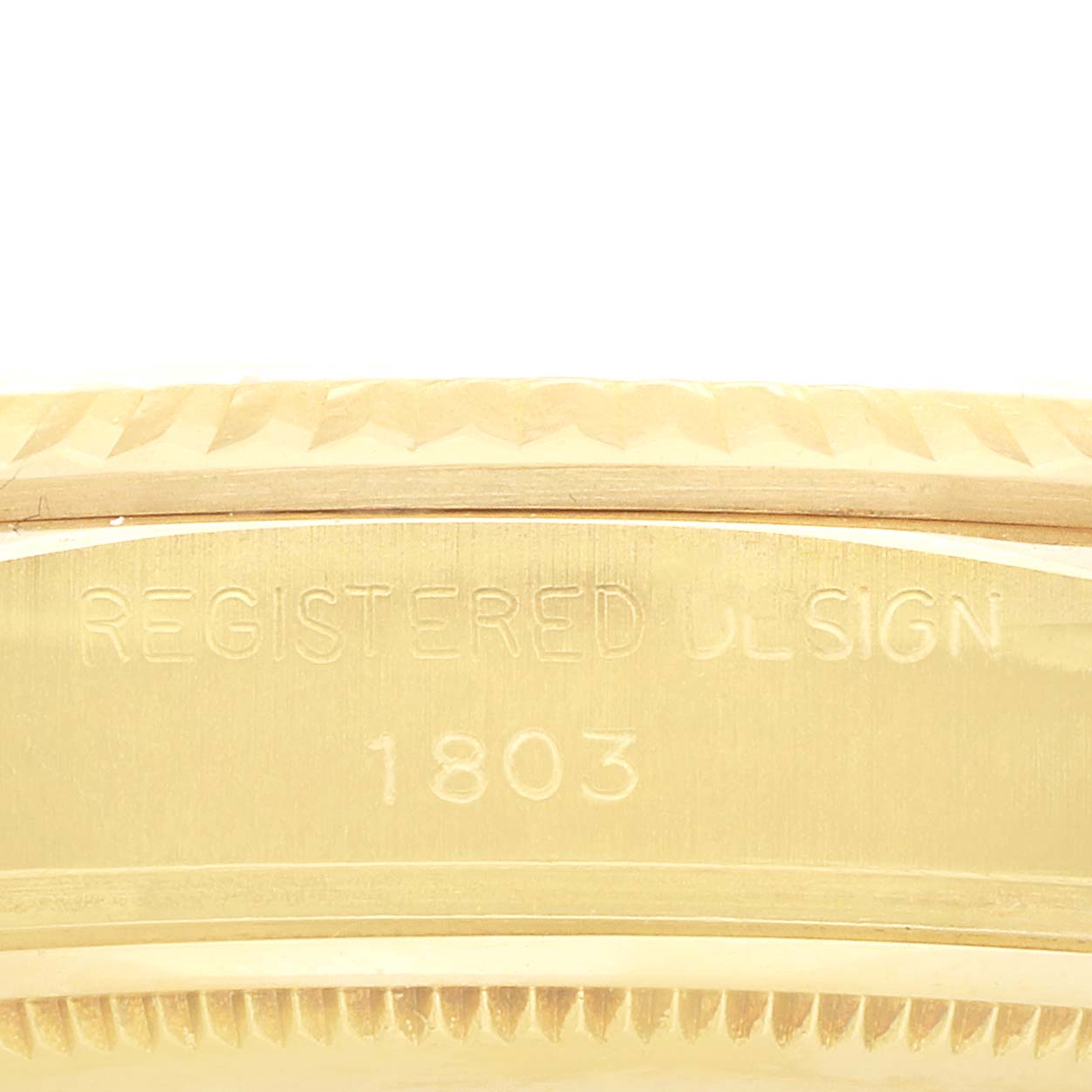 The image shows a close-up of the side of a Rolex President 18038 Men's Yellow Gold Champagne Dial model, highlighting the "Registered Design 1803" engraving on its case.