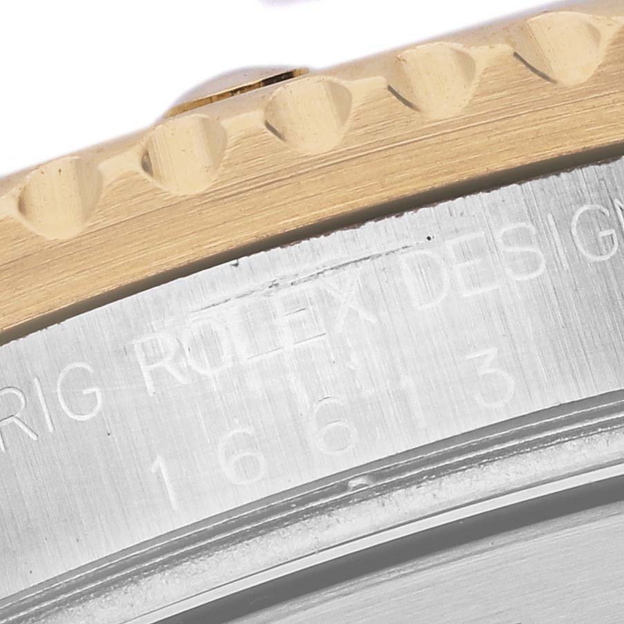 The image shows a close-up of the bezel and edge of the case of a Rolex Submariner 16613 Men's Steel and Gold (two tone) Blue Dial 16613 Men's Steel and Gold (two tone) Blue Dial watch, highlighting the engravings.
