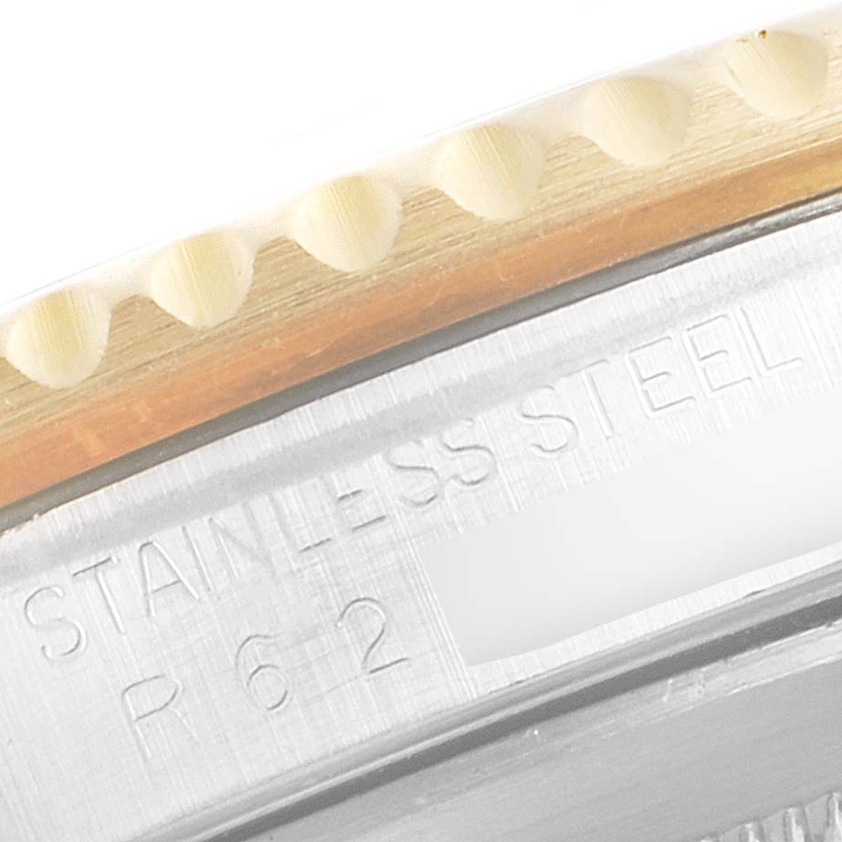 This image shows a close-up of the stainless steel caseback and edge of the bezel of a Rolex Submariner 16803 Men's Steel and Gold (two tone) Black Dial 16803 Men's Steel and Gold (two tone) Black Dial watch.