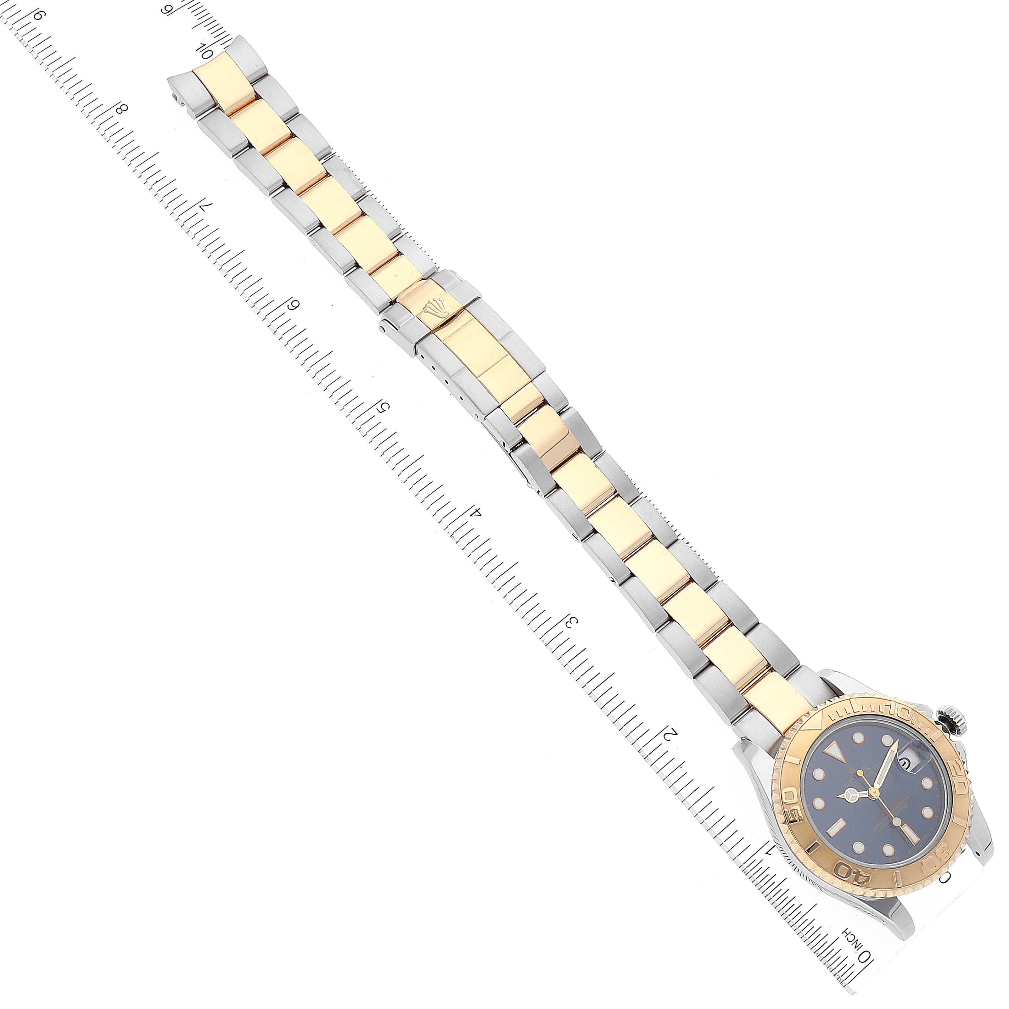 The image shows a top-down view of a Rolex Yacht-Master 68623 Men
s Steel and Gold (two tone) Blue Dial 68623 Men
s Steel and Gold (two tone) Blue Dial watch, fully extended with a two-tone bracelet alongside a ruler.