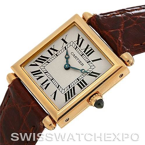 The image shows a Cartier Tank Obus Yellow Gold Silver Dial Yellow Gold Silver Dial watch at an angled view highlighting the face, Roman numerals, bezel, crown, and leather strap.