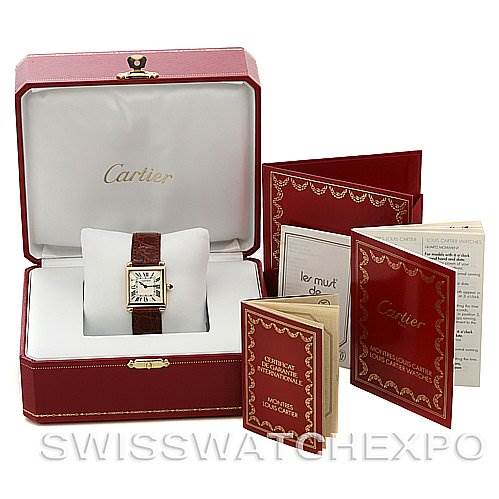 The image shows a Cartier Tank Obus Yellow Gold Silver Dial Yellow Gold Silver Dial watch in its box with accompanying booklets and documents.