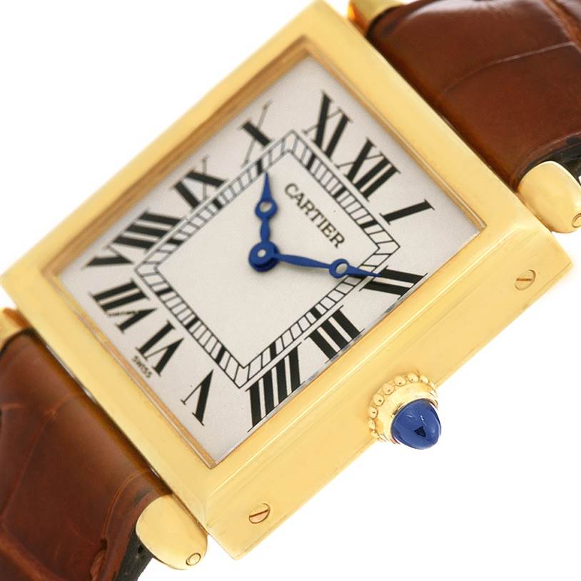 This image shows a close-up angle of the Cartier Tank Obus W1512256 Yellow Gold Silver Dial W1512256 Yellow Gold Silver Dial watch, highlighting its dial, hands, bezel, and part of the leather strap.