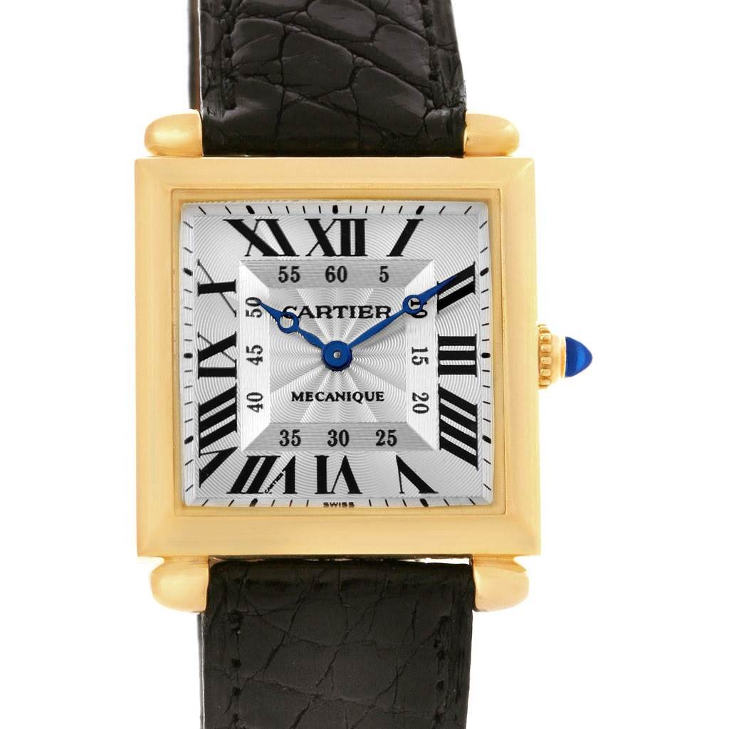 The image shows a close-up, front view of the Cartier Tank Obus W1527551 Men's Yellow Gold Silver Dial W1527551 Men's Yellow Gold Silver Dial watch, displaying the dial, hands, case, crown, and part of the leather strap.