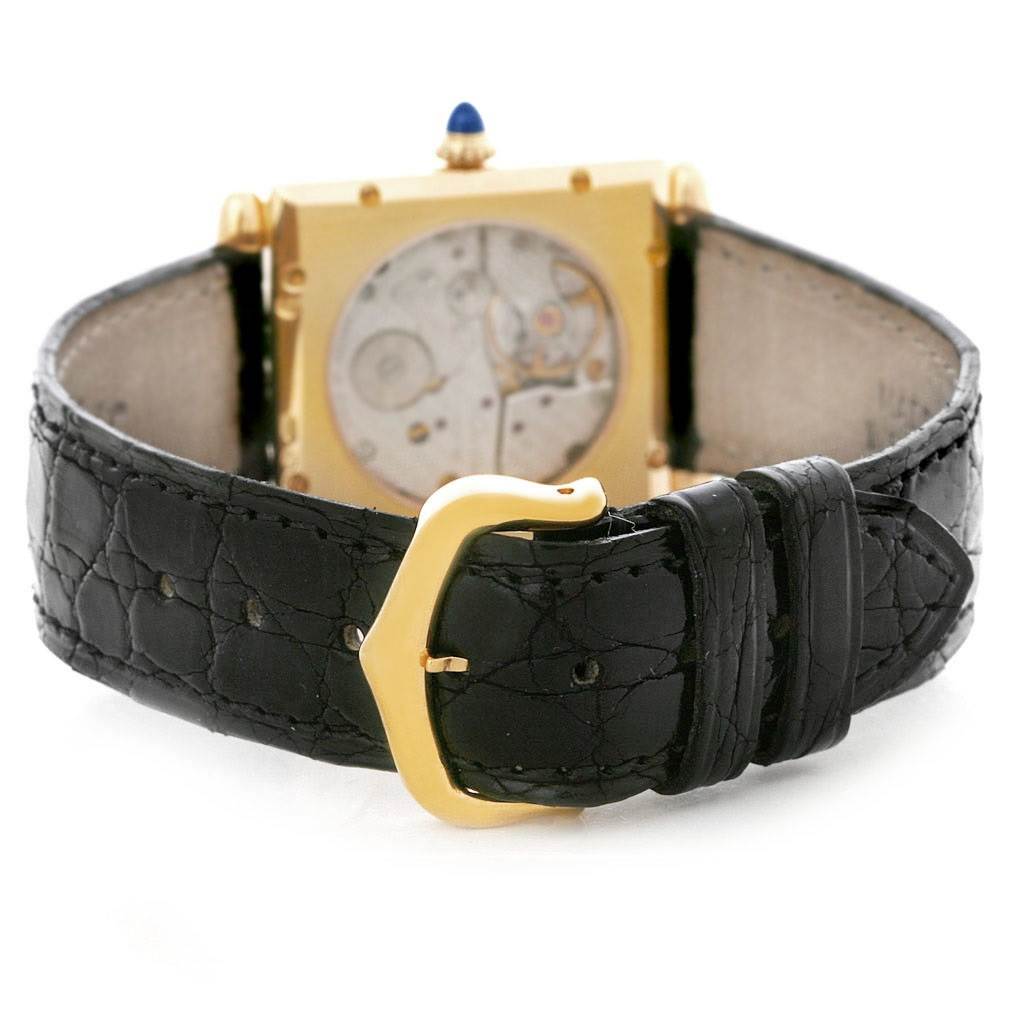 This image shows the back side of the Cartier Tank Obus W1527551 Men's Yellow Gold Silver Dial W1527551 Men's Yellow Gold Silver Dial watch, highlighting the movement and black leather strap with a gold buckle.