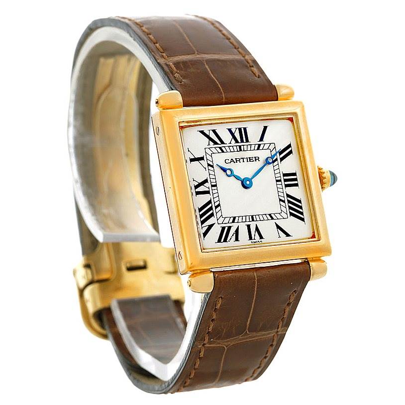 The Cartier Tank Obus Men's Yellow Gold Silver Dial Men's Yellow Gold Silver Dial watch is shown from a side angle, highlighting its square face, Roman numeral dial, and brown leather strap.