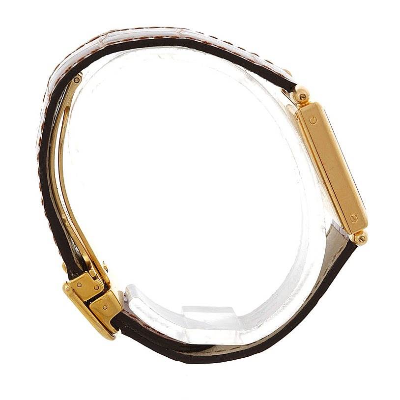 This side-angle image of the Cartier Tank Obus Men's Yellow Gold Silver Dial Men's Yellow Gold Silver Dial model shows the gold rectangular case, lugs, and part of the black leather strap.