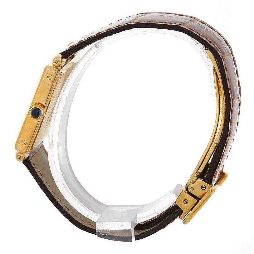 The image shows a side view of a Cartier Tank Obus Men's Yellow Gold Silver Dial Men's Yellow Gold Silver Dial watch, highlighting the gold casing, crown, and brown leather strap.