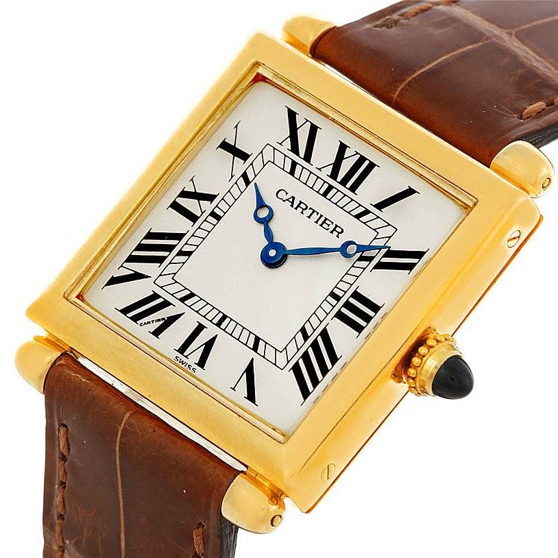 The image shows a close-up, tilted view of the Cartier Tank Obus Men's Yellow Gold Silver Dial Men's Yellow Gold Silver Dial watch, highlighting its face and leather strap.