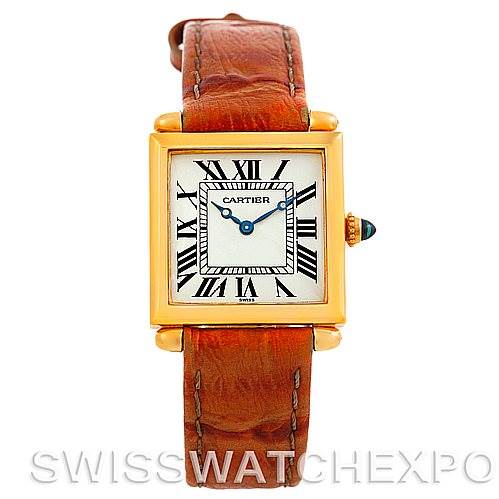 The Cartier Tank Obus Men
s Yellow Gold Silver Dial Men
s Yellow Gold Silver Dial watch is shown from the front, featuring a gold case, Roman numeral dial, and brown leather strap.