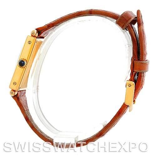 The image shows a side profile of a Cartier Tank Obus Men
s Yellow Gold Silver Dial Men
s Yellow Gold Silver Dial watch highlighting its gold bezel, crown, and brown leather strap.