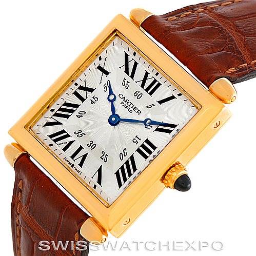 This image shows a Cartier Tank Obus W1527551 Men's Yellow Gold Silver Dial W1527551 Men's Yellow Gold Silver Dial watch from a slightly angled, overhead perspective, highlighting the dial, case, crown, and leather strap.