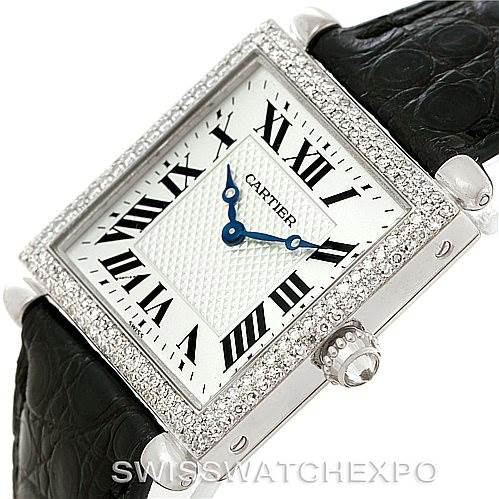 The image shows a Cartier Tank Obus Men's White Gold Silver Dial Men's White Gold Silver Dial watch from an angle highlighting its rectangular face, blue hands, leather strap, and diamond-studded bezel.