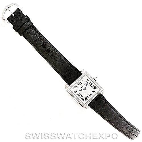 The image shows a top-down view of a Cartier Tank Obus Men's White Gold Silver Dial Men's White Gold Silver Dial watch with a black leather strap and a square, silver, Roman numeral dial.