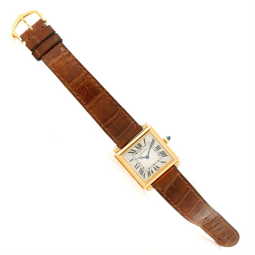 This Tank Obus model by Cartier is shown from a top-down angle, showcasing the entire watch including the face, strap, and buckle.