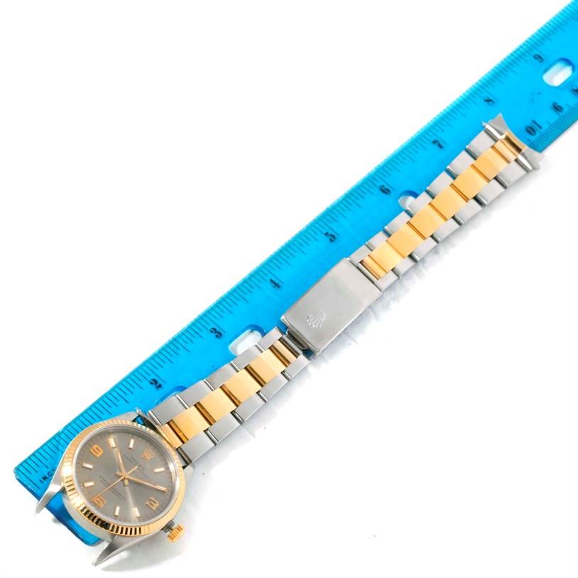 The image shows a Rolex Oyster Perpetual 14233 Men's Steel and Gold (two tone) Grey Dial 14233 Men's Steel and Gold (two tone) Grey Dial watch, including the face, bracelet, and clasp, positioned next to a ruler for scale.