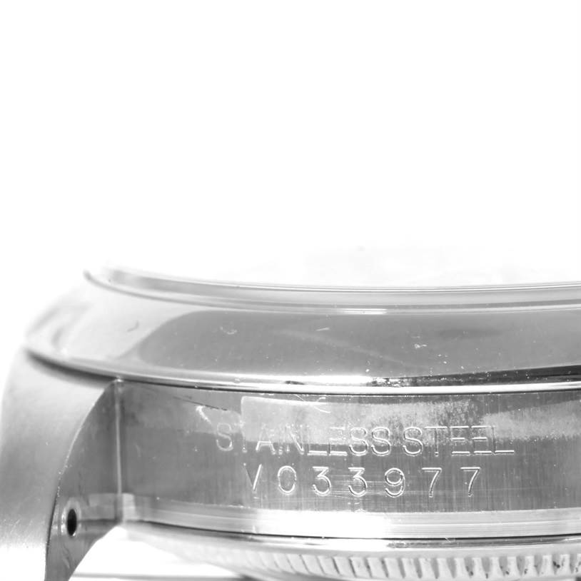 This image shows a close-up of the side of a Rolex Oyster Perpetual 116000 Men's Black Dial 116000 Men's Black Dial watch, highlighting the stainless steel casing and serial number.